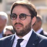 Vincenzo d'incecco con occhiali da sole e in giacca e cravatta