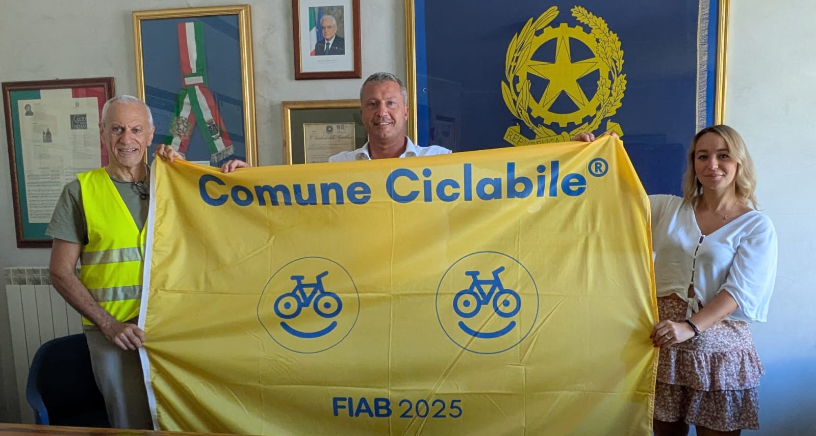 Un assessore e una consigliera del Comune di Montesilvano mantengono la Bandiera Gialla FIAB insieme a una terza persona