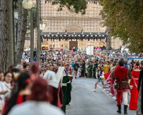 Un momento del Corteo della Bolla della Perdonanza Celestiniana, con figuranti in abiti medievali lungo le vie del centro storico dell’Aquila.