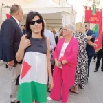 La consigliera comunale Simona Giannangeli sfila nel corteo della Perdonanza indossando un abito con i colori della bandiera palestinese. Con lei, altri consiglieri di minoranza hanno esposto un maxi-vessillo