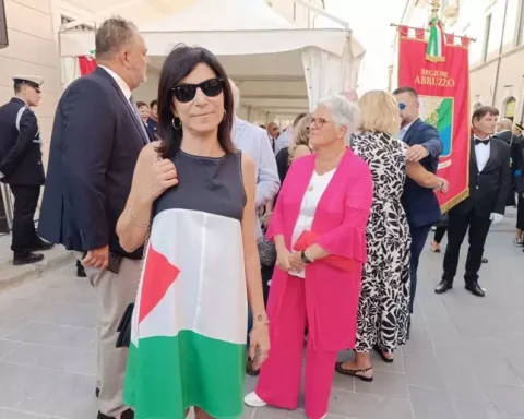 La consigliera comunale Simona Giannangeli sfila nel corteo della Perdonanza indossando un abito con i colori della bandiera palestinese. Con lei, altri consiglieri di minoranza hanno esposto un maxi-vessillo