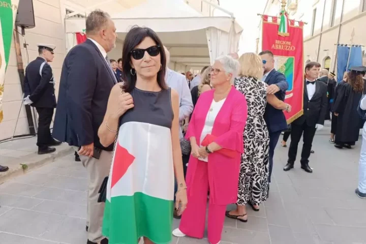 La consigliera comunale Simona Giannangeli sfila nel corteo della Perdonanza indossando un abito con i colori della bandiera palestinese. Con lei, altri consiglieri di minoranza hanno esposto un maxi-vessillo
