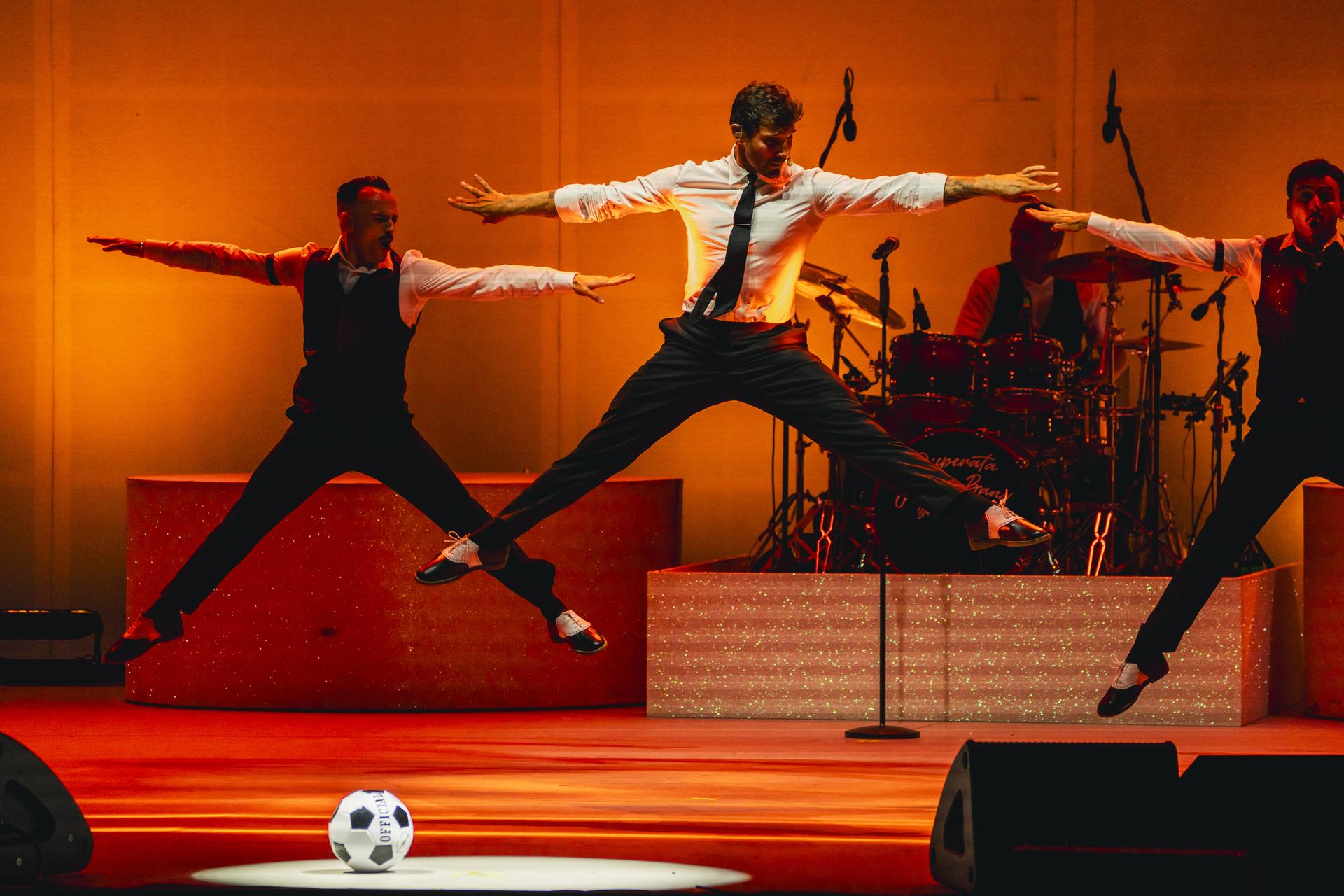 Stefano De Martino durante una coreografia di “Meglio Stasera Summer Tour 2025”, accompagnato dai ballerini e dalla Disperata Erotica Band