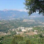 Uno scorcio della Valle Subequana con il borgo di Santa Maria del Ponte incastonato tra boschi e colline, ai piedi del massiccio del Sirente. Qui si svolge la festa patronale di San Pancrazio, tra spiritualità, sapori abruzzesi e comicità popolare. Un contesto intimo e autentico, lontano dai riflettori