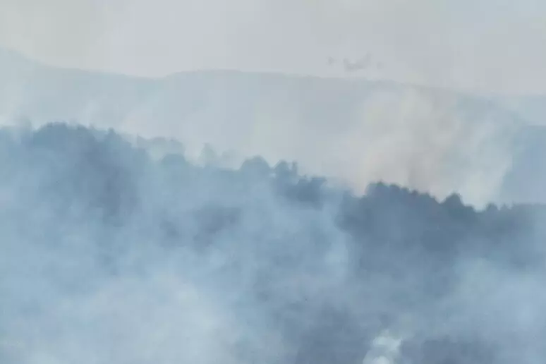 Un fitto fumo si alza dal bosco sul Monte Salviano, dove mezzi aerei e squadre a terra sono impegnati da ore nelle operazioni di spegnimento