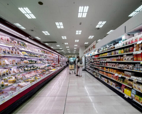 Persone che fanno acquisti spingendo il carrello in un supermercato, immagine che richiama l’uso della social card del Bonus Spesa