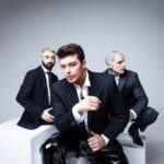 l trio dei The Kolors – Stash e Alex Fiordispino insieme a Dario Iaculli – durante una performance dal vivo: sul palco del Summer Tour 2025 portano energia, pop ed elettronica, attesi stasera all’Aquila per il concerto alla Scalinata di San Bernardino
