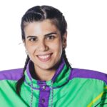 una ragazza con le trecce che indossa un giubbotto viola e verde