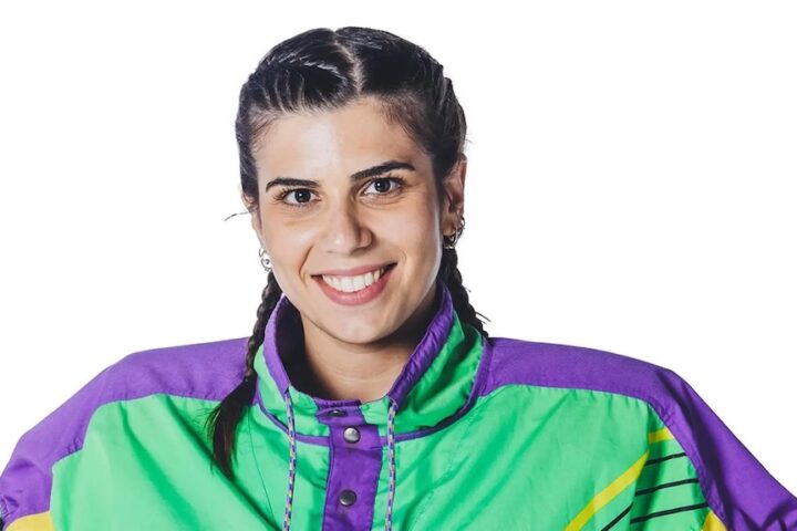una ragazza con le trecce che indossa un giubbotto viola e verde