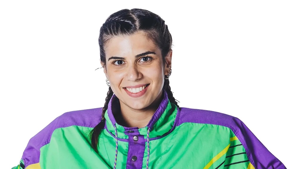 una ragazza con le trecce che indossa un giubbotto viola e verde