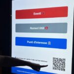 schermi digitali a Montesilvano. una mano indica un qr code
