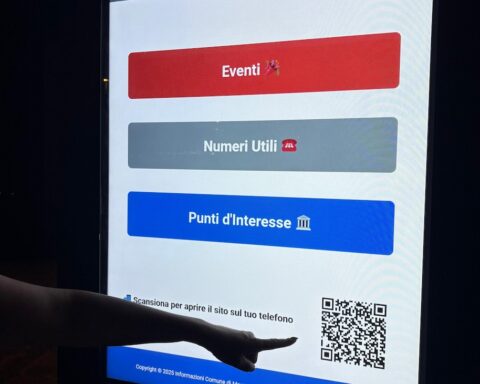schermi digitali a Montesilvano. una mano indica un qr code