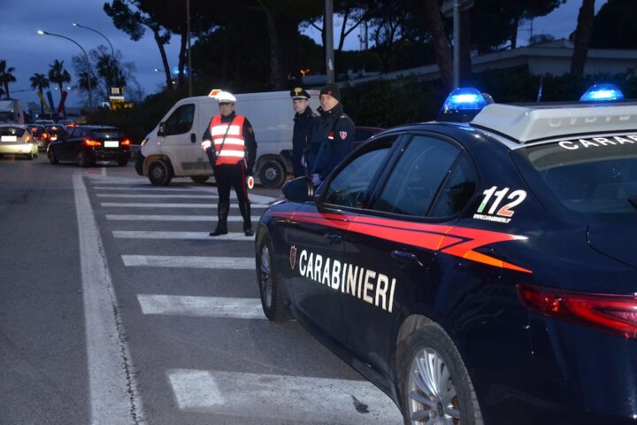 carabinieri di notte sulla strada con auto d'ordinanza