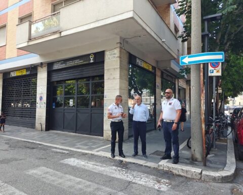 il sindaco masci e due agenti della polizia locale a passeggio per le vie del centro di pescara per verificare il degrado urbano. si vedono saracinesche e negozi, strisce pedonali e un cartello stradale