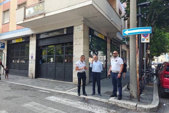 il sindaco masci e due agenti della polizia locale a passeggio per le vie del centro di pescara per verificare il degrado urbano. si vedono saracinesche e negozi, strisce pedonali e un cartello stradale