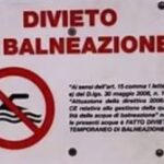 Cartello di divieto di balneazione con sfondo del mare