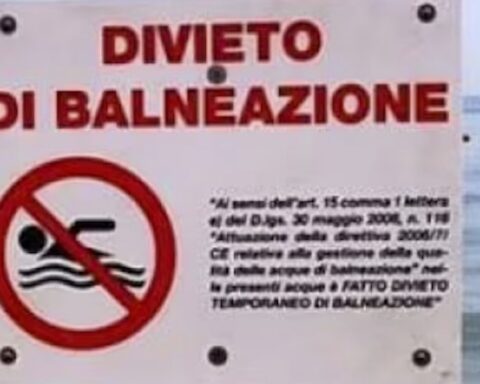 Cartello di divieto di balneazione con sfondo del mare