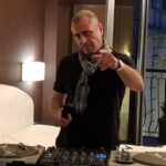 Marco La Sorda DJ. Un uomo in un interno con consolle e cuffie