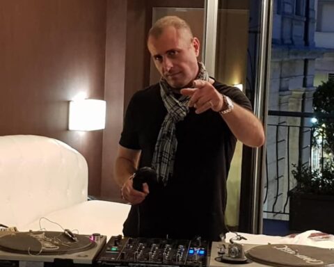 Marco La Sorda DJ. Un uomo in un interno con consolle e cuffie