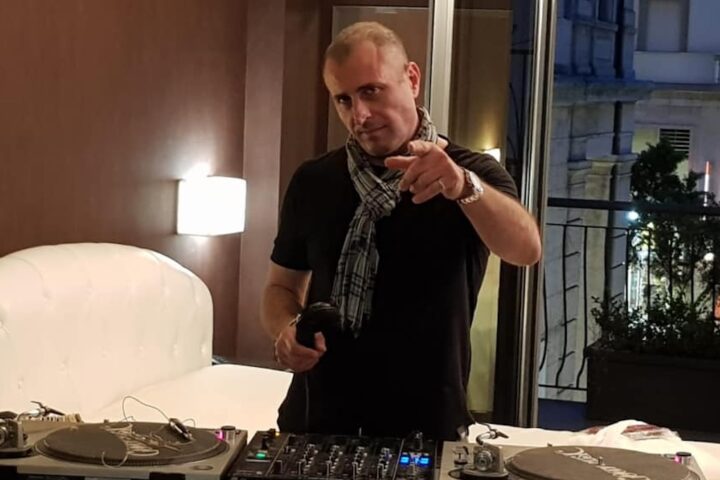 Marco La Sorda DJ. Un uomo in un interno con consolle e cuffie
