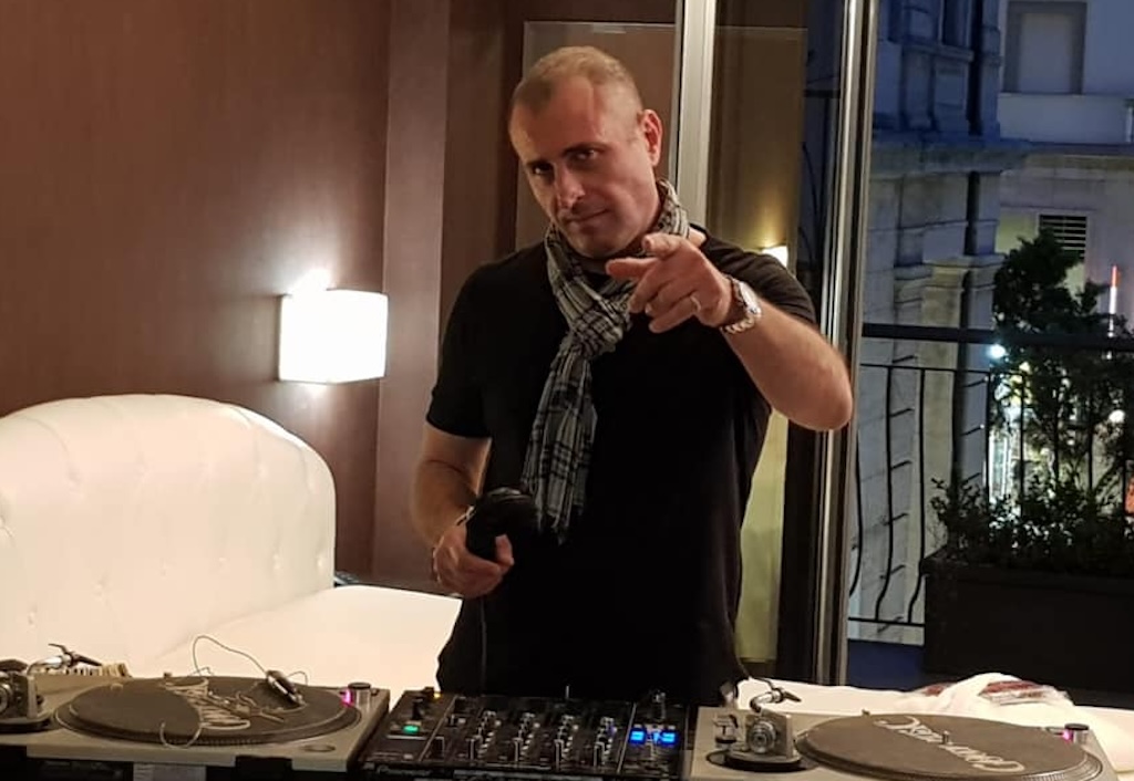 Marco La Sorda DJ. Un uomo in un interno con consolle e cuffie