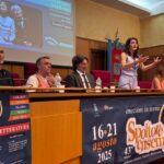 alcune persone sedute ad un tavolo parlano e presentano un evento