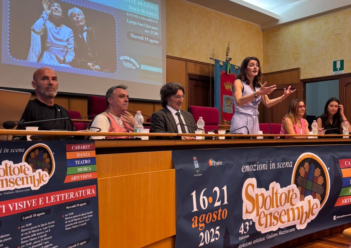 alcune persone sedute ad un tavolo parlano e presentano un evento