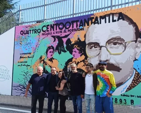 Il murales dedicato a Mario Magnotta inaugurato a Colle Sapone, firmato dall’artista Daniele Gottastia. Accanto all’opera, la figlia Romina, il sindaco Biondi e gli autori degli scherzi riuniti per celebrare il “Magnotta Day”