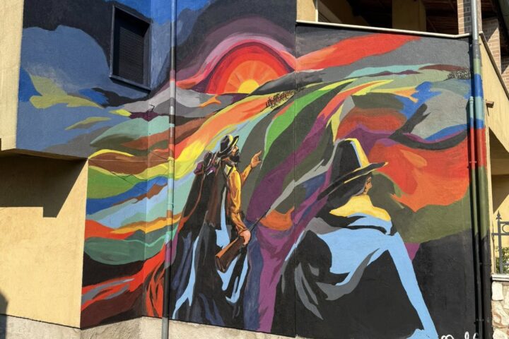 Uno dei nuovi murales realizzati a Sante Marie sulle case di edilizia residenziale pubblica: colori vivaci e figure simboliche trasformano le facciate in opere d’arte