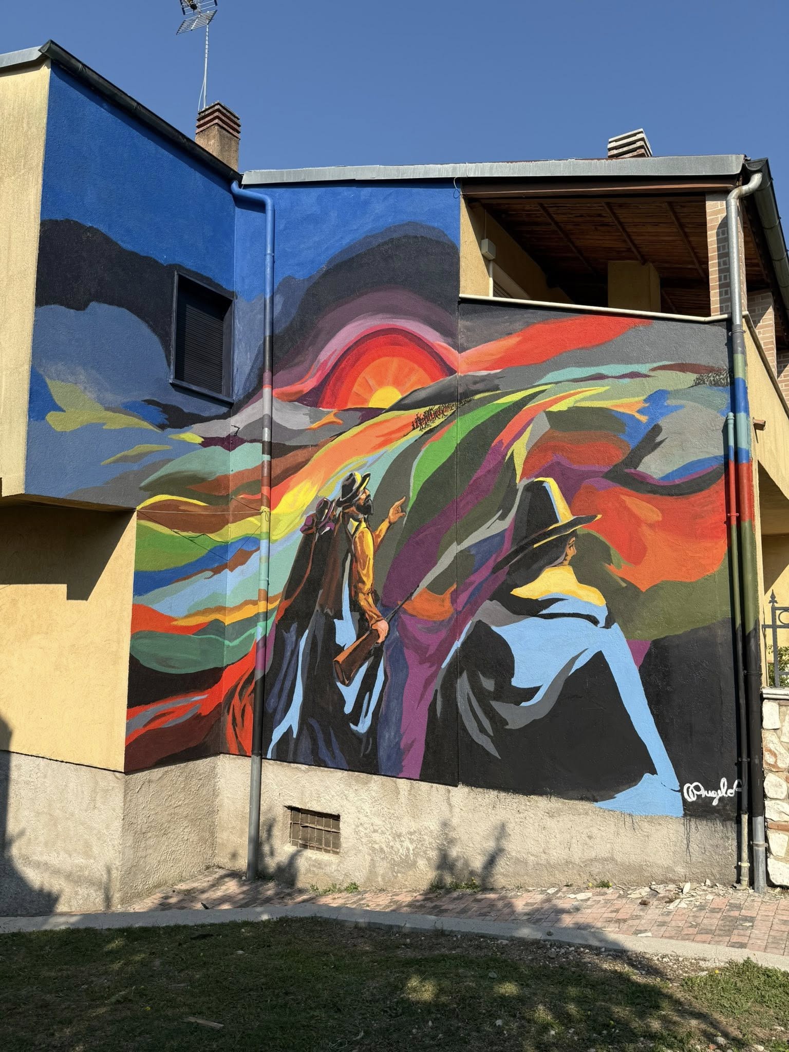 Uno dei nuovi murales realizzati a Sante Marie sulle case di edilizia residenziale pubblica: colori vivaci e figure simboliche trasformano le facciate in opere d’arte