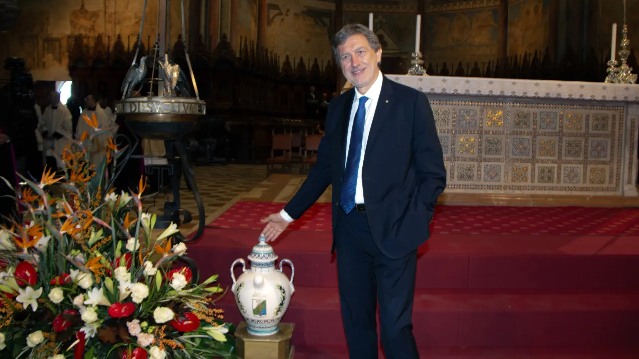 Il presidente della Regione Abruzzo, Marco Marsilio, accanto a una delle anfore in ceramica aquilana con l’olio offerto per alimentare la Lampada votiva dei Comuni d’Italia nella Basilica di San Francesco ad Assisi