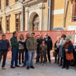 Un gruppo di cittadini davanti alle macerie di Palazzo Carli, in piazza Rivera, durante il flash mob promosso per chiederne la ricostruzione