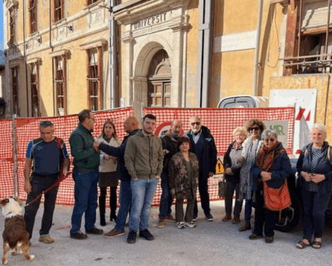 Un gruppo di cittadini davanti alle macerie di Palazzo Carli, in piazza Rivera, durante il flash mob promosso per chiederne la ricostruzione
