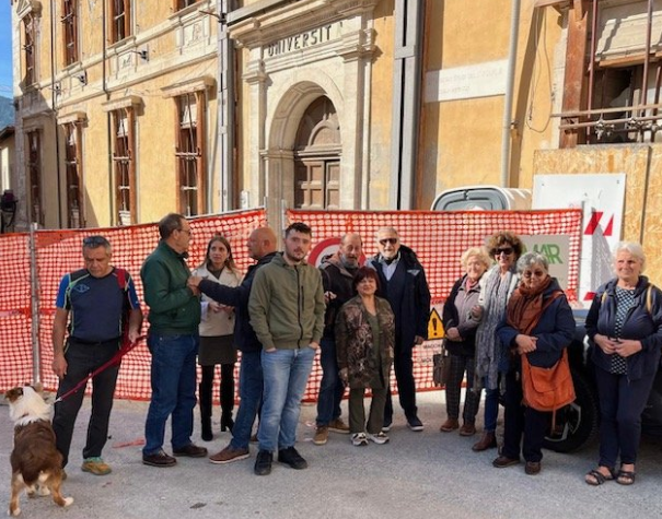 Un gruppo di cittadini davanti alle macerie di Palazzo Carli, in piazza Rivera, durante il flash mob promosso per chiederne la ricostruzione