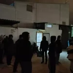 Gruppi di migranti raccolti nei pressi della Questura dell’Aquila, dove molti trascorrono la notte all’aperto dopo la rimozione di coperte e cartoni segnalata dai residenti