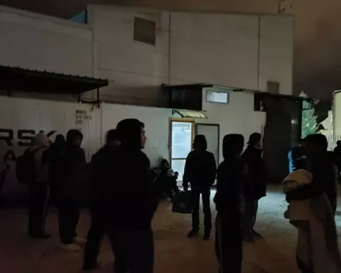 Gruppi di migranti raccolti nei pressi della Questura dell’Aquila, dove molti trascorrono la notte all’aperto dopo la rimozione di coperte e cartoni segnalata dai residenti