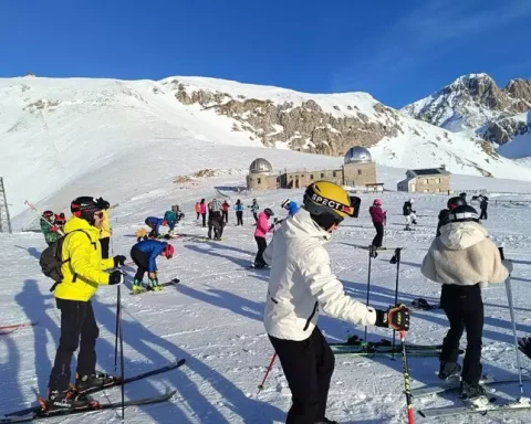Sciatori e appassionati affollano le piste delle Fontari a Campo Imperatore nel giorno della riapertura della stagione invernale. Sullo sfondo l’altopiano innevato e le strutture dell’osservatorio, in una giornata di sole e grande affluenza