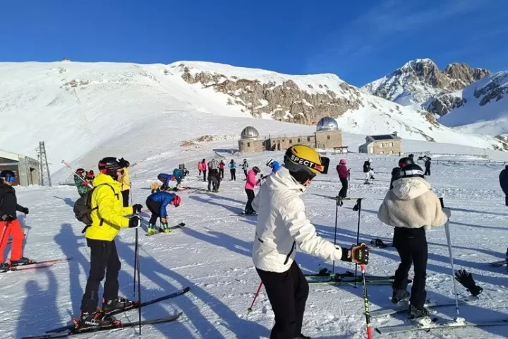 Sciatori e appassionati affollano le piste delle Fontari a Campo Imperatore nel giorno della riapertura della stagione invernale. Sullo sfondo l’altopiano innevato e le strutture dell’osservatorio, in una giornata di sole e grande affluenza